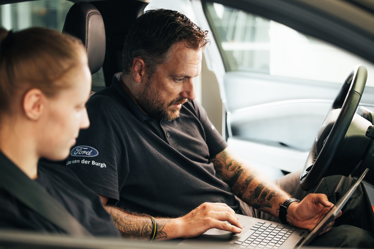 Ford technisch specialist met laptop in de auto