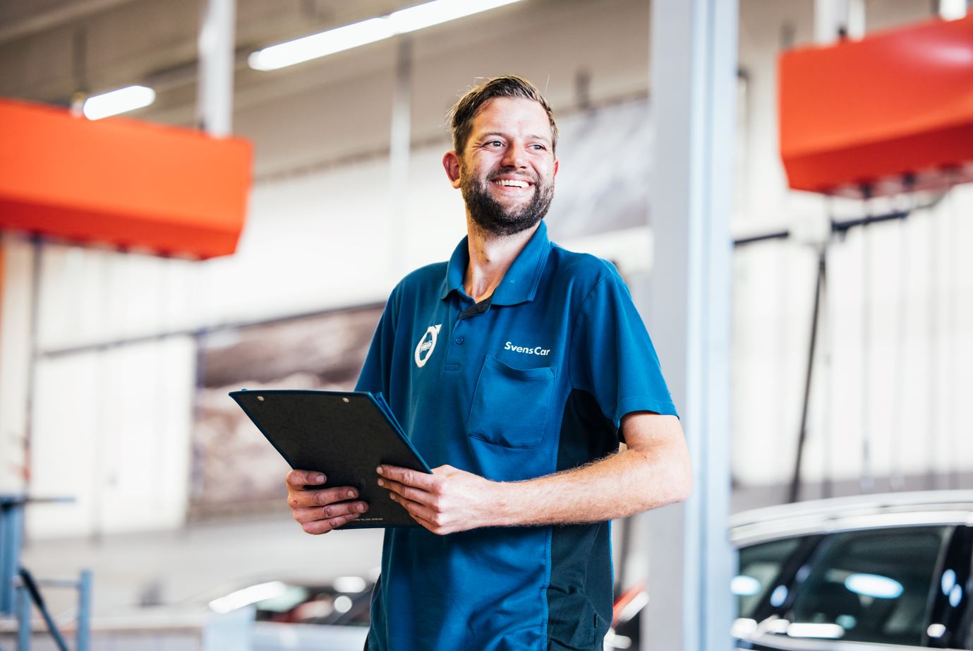 Service Adviseur Volvo lachend met iets in zijn handen