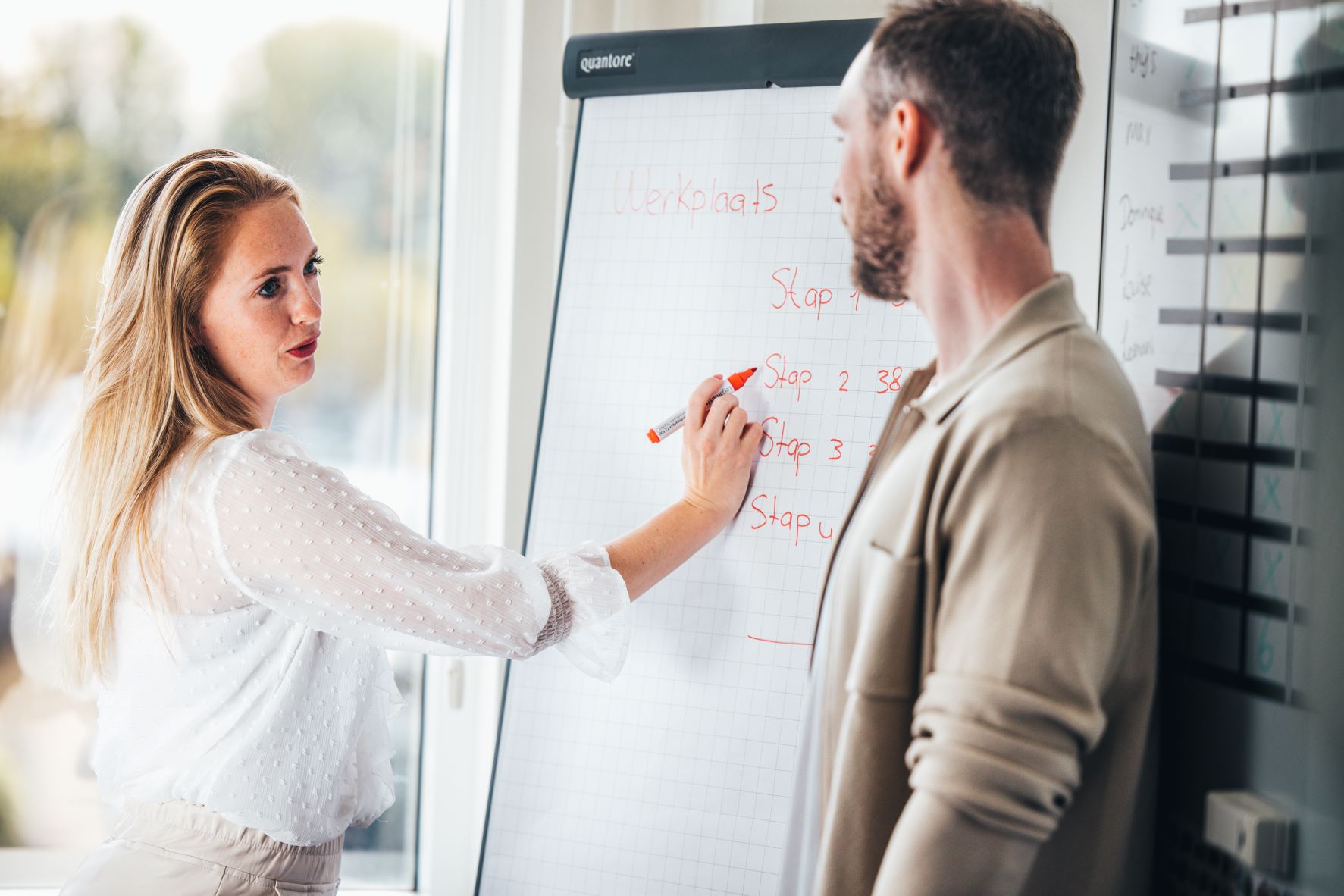 Marketing overleg man en vrouw bij whiteboard