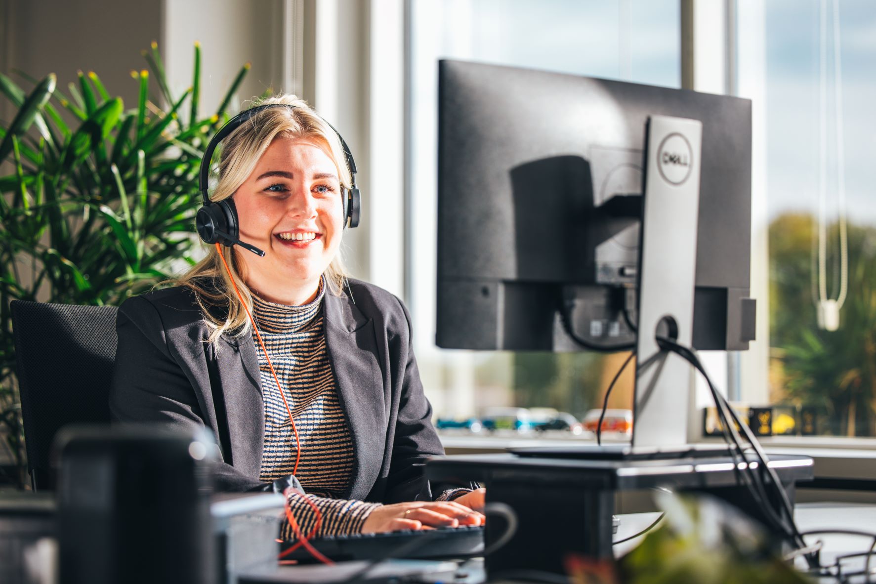 Online Sales vrouw achter computer met headset op