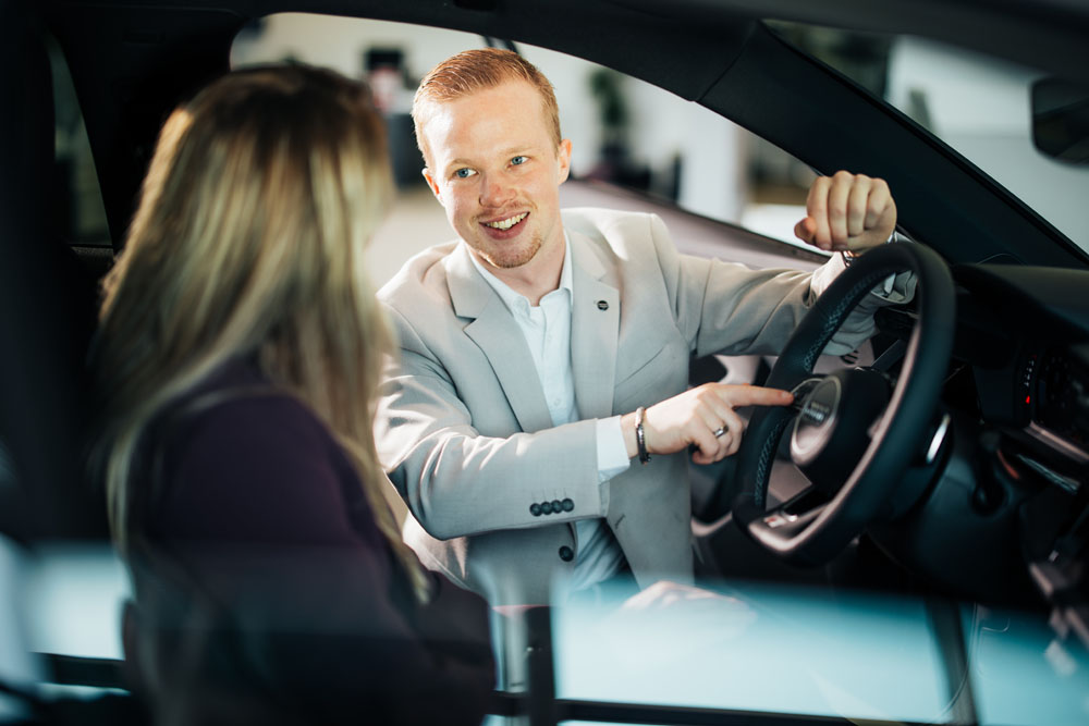 Audi service adviseur dingen aan het laten zien bij het interieur van een audi