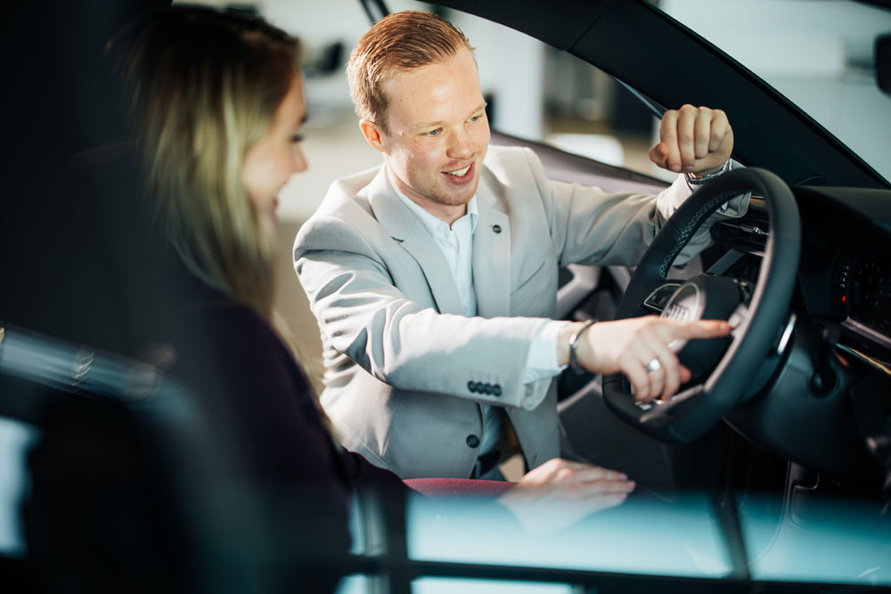 klant in een auto met service adviseur die dingen aanwijst