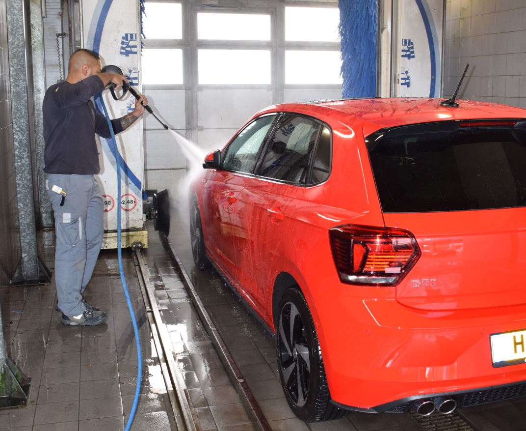 Autowasser rode auto aan het schoonmaken