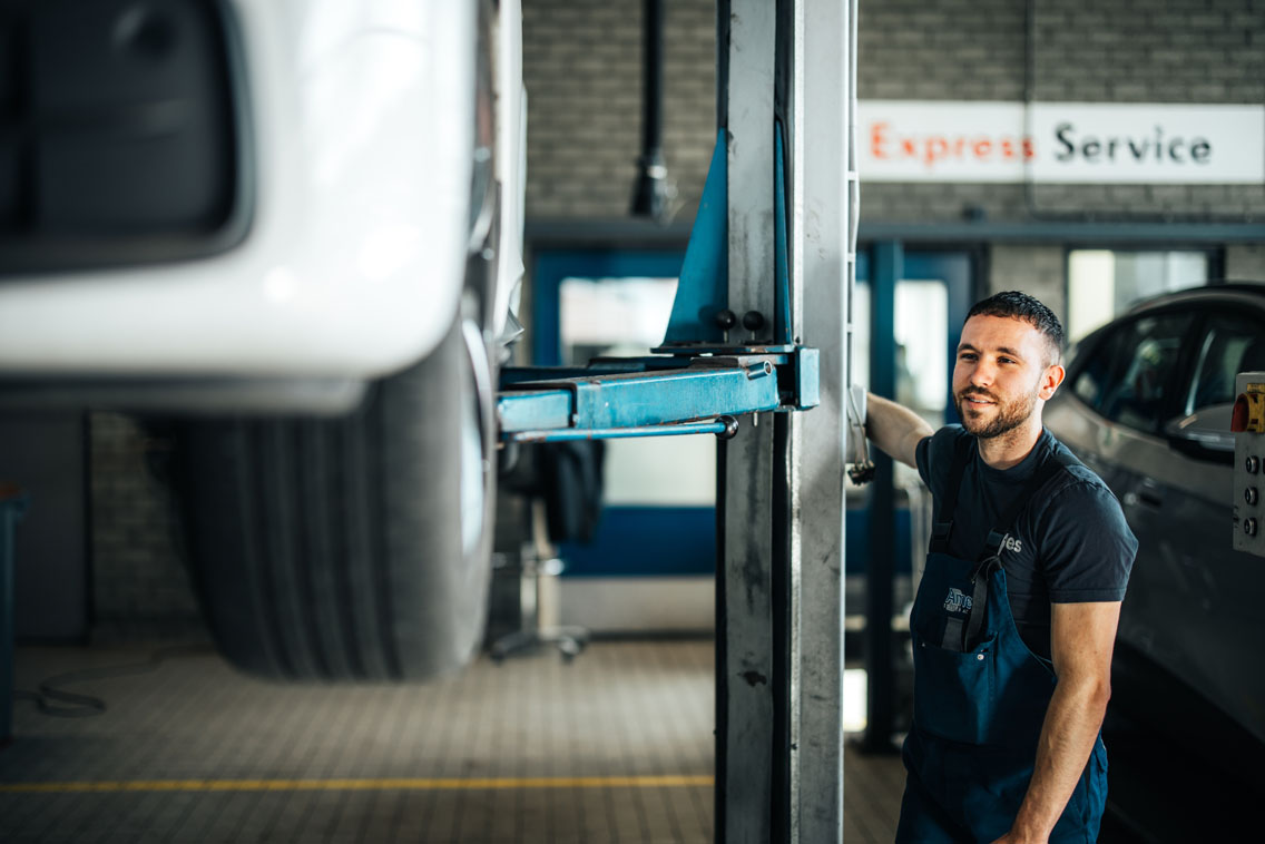 Ames Volkswagen monteur bij een hefbrug