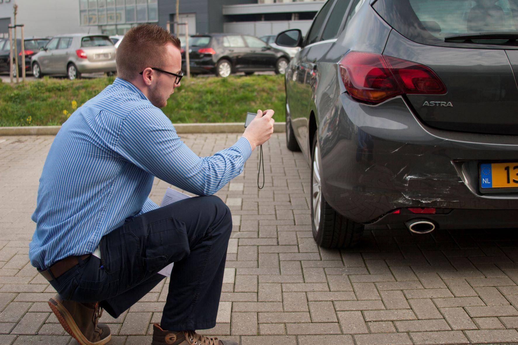 Schadecalculator man die foto's aan het maken is van kapotte auto