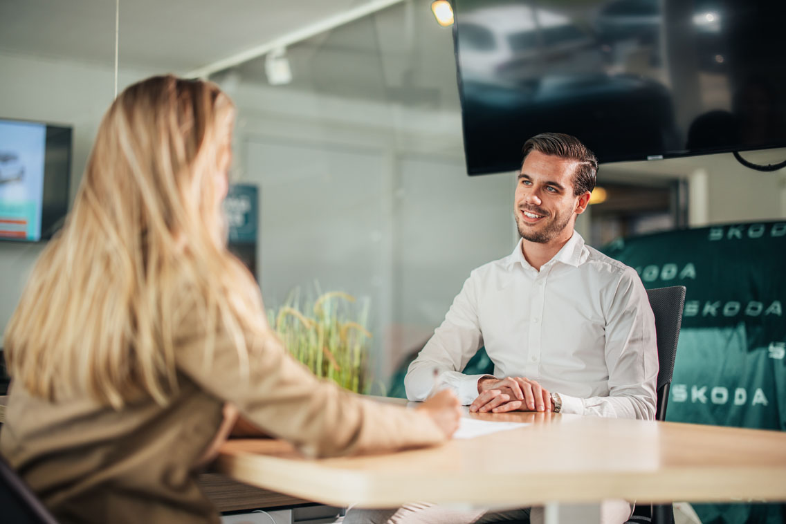 verkoper en klant zitten aan een tafel in gesprek