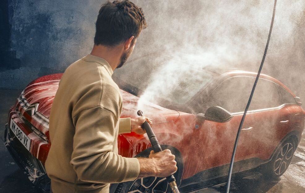 Autowasser bezig met rode auto